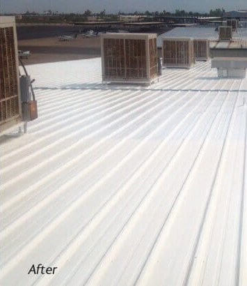 Corrugated metal commercial roof restored with a reflective white coating sealing the seams and fasteners
